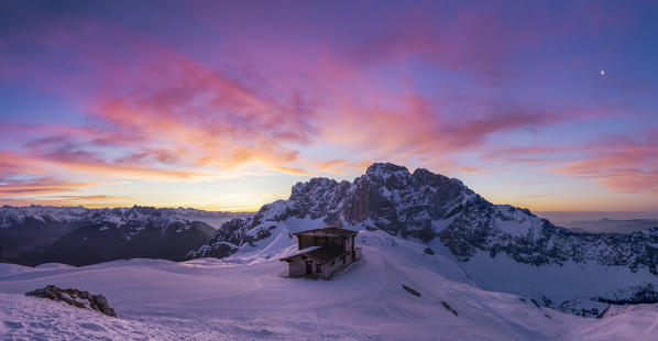 View of the snow-covered north face of the Presolana mountain in winter at sunrise with the Aquila refuge. Colere, Val di Scalve, Bergamo district, Lombardy, Italy, Southern Europe.