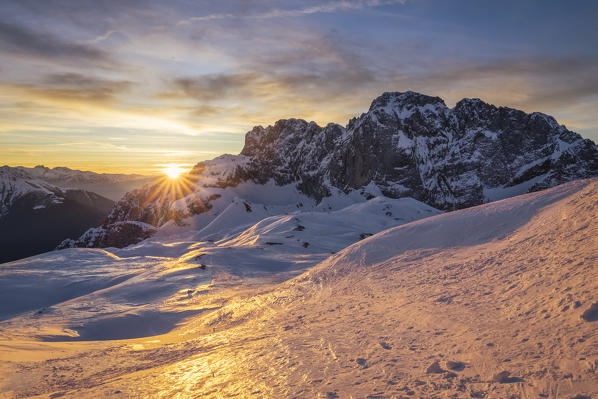 View of the snow-covered north face of the Presolana mountain in winter at sunrise. Val di Scalve, Bergamo district, Lombardy, Italy, Southern Europe.
