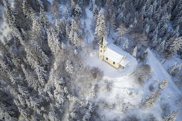 Aerial view of the Silvestri church after a winter sunrise. Presolana pass, Castione della Presolana, Seriana Valley, Bergamo province, Lombardy, Italy.