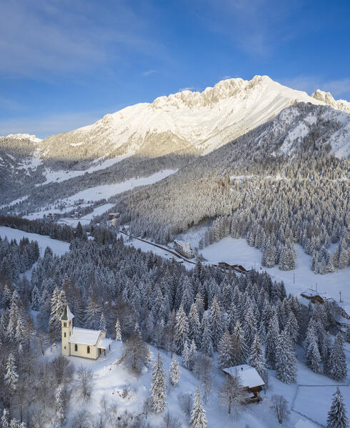 Aerial view of the Silvestri church and the Presolana massif after a winter sunrise. Presolana pass, Castione della Presolana, Seriana Valley, Bergamo province, Lombardy, Italy.