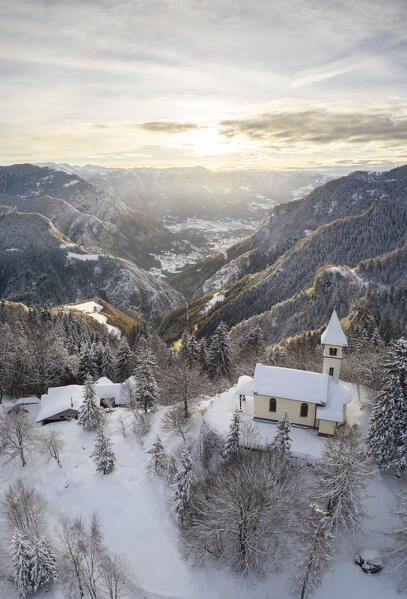 Aerial view of the Silvestri church and the Scalve valley after a winter sunrise. Presolana pass, Colere, Seriana Valley, Bergamo province, Lombardy, Italy.