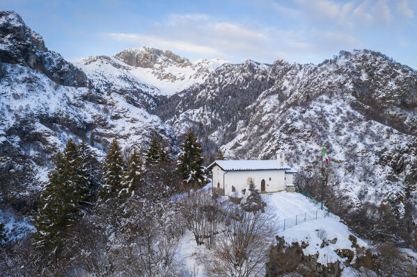 Aerial view of the small church called San Peder and the Presolana during a winter sunset. Rusio, Castione della Presolana, Val Seriana, Bergamo district, Lombardy, Italy.
