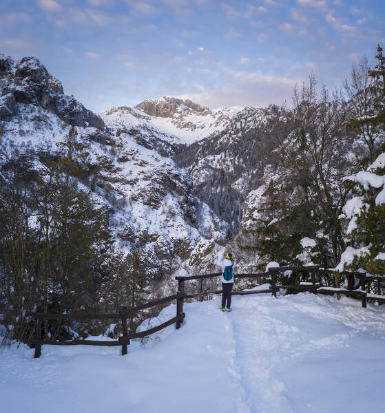 A trekker looking at the Presolana from the small church called San Peder. Rusio, Castione della Presolana, Val Seriana, Bergamo district, Lombardy, Italy.