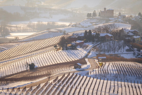 View of the road to the castle of Grinzane Cavour in winter after a snowfall. Langhe, Cuneo district, Piedmont, Italy.