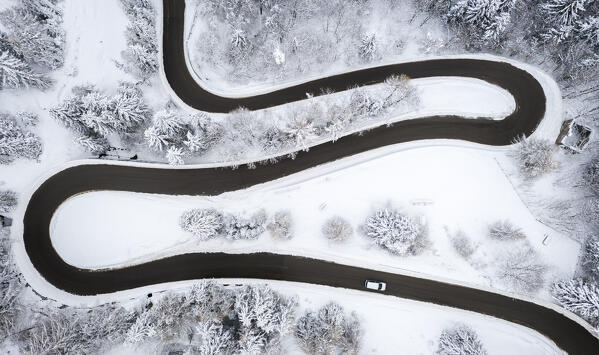 Aerial view of the winding road of the Presolana Pass after a winter snowfall. Presolana pass, Colere, Seriana Valley, Bergamo province, Lombardy, Italy.