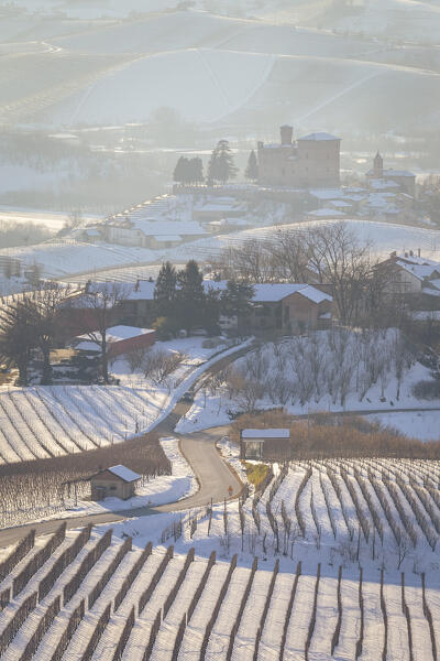View of the road to the castle of Grinzane Cavour in winter after a snowfall. Langhe, Cuneo district, Piedmont, Italy.