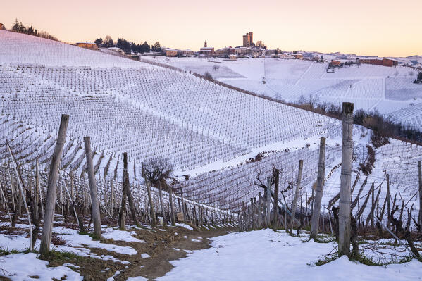 Winter sunset on the medieval town of Serralunga d'Alba and its castle viewed from the surrounding vineyards. Serralunga d'Alba, Langhe, Piedmont, Italy, Europe.
