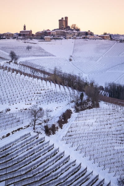 Winter sunset on the medieval town of Serralunga d'Alba and its castle viewed from the surrounding vineyards. Serralunga d'Alba, Langhe, Piedmont, Italy, Europe.