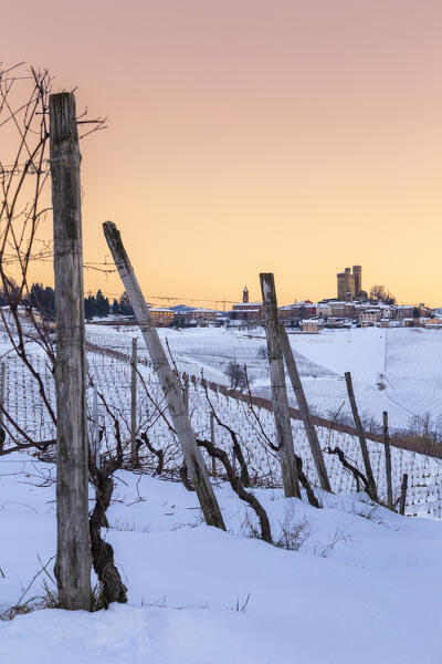 Winter sunset on the medieval town of Serralunga d'Alba and its castle viewed from the surrounding vineyards. Serralunga d'Alba, Langhe, Piedmont, Italy, Europe.