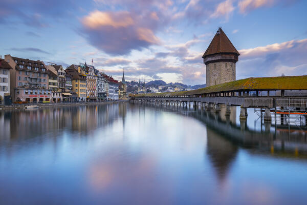 View of the Kapellbrücke bridge and the Wasserturm at sunset reflected on the Reuss river. Lucerne, canton of Lucerne, Switzerland.