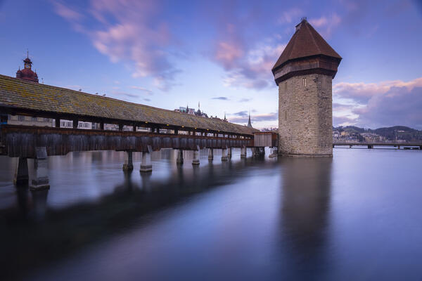 View of the Kapellbrücke bridge and the Wasserturm at sunset reflected on the Reuss river. Lucerne, canton of Lucerne, Switzerland.