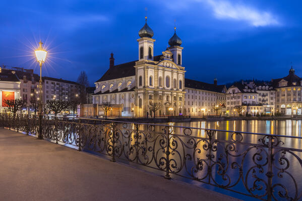 View of the Jesuit Church and the old town of Lucerne at blue hour reflected on the Reuss river. Lucerne, canton of Lucerne, Switzerland.