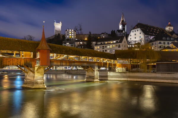 View of the wooden footbridge of Spreuerbrücke at night reflected on the Reuss river. Lucerne, canton of Lucerne, Switzerland.