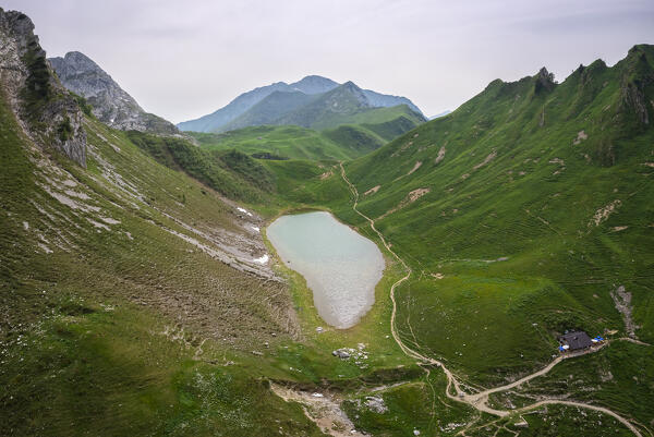 Aerial view of the Branchino lake and Rifugio Branchino during spring time. Valcanale, Ardesio, Val Seriana, Bergamo district, Lombardy, Italy, Southern Europe.