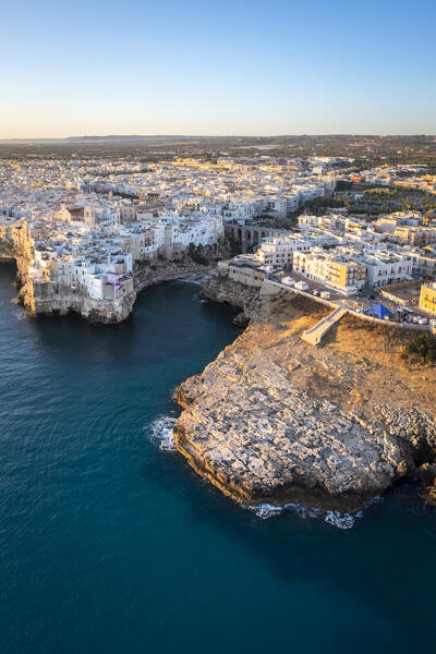 Aerial view of the overhanging houses of Polignano a Mare at sunrise. Bari district, Apulia, Italy, Europe.

