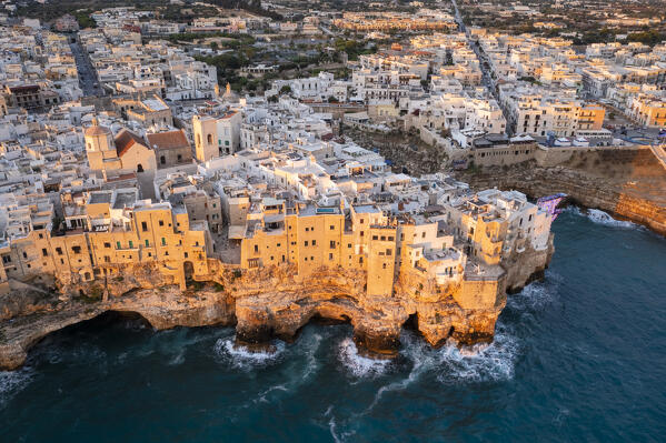 Aerial view of the overhanging houses of Polignano a Mare at sunrise. Bari district, Apulia, Italy, Europe.