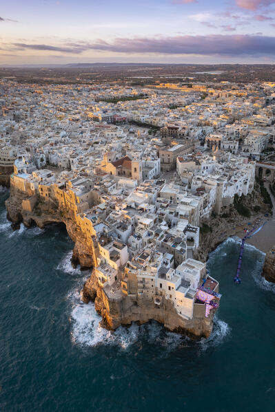 Aerial view of the overhanging houses of Polignano a Mare at sunrise. Bari district, Apulia, Italy, Europe.