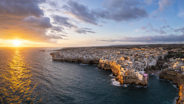 Aerial view of the overhanging houses of Polignano a Mare at sunrise. Bari district, Apulia, Italy, Europe.