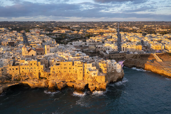 Aerial view of the overhanging houses of Polignano a Mare at sunrise. Bari district, Apulia, Italy, Europe.