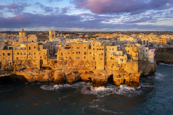 Aerial view of the overhanging houses of Polignano a Mare at sunrise. Bari district, Apulia, Italy, Europe.