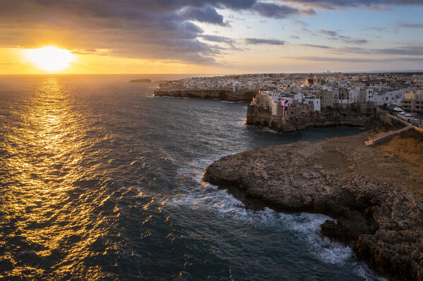 Aerial view of the overhanging houses of Polignano a Mare at sunrise. Bari district, Apulia, Italy, Europe.