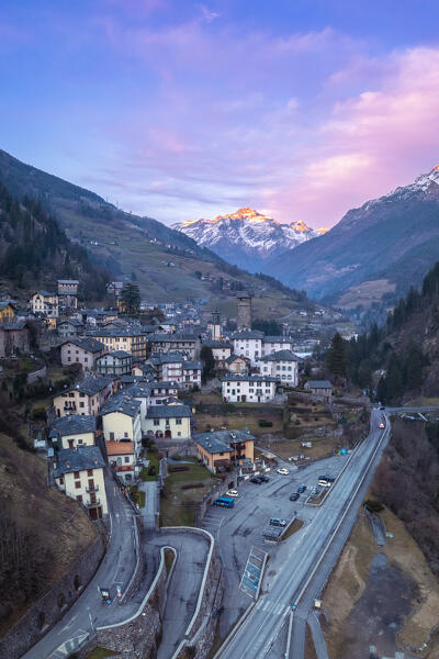 The village of Gromo with Pizzo Redorta illuminated at sunset in the background. Gromo, Val Seriana, Bergamo province, Lombardy, Italy, Europe.