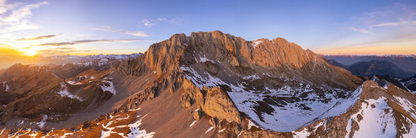 Aerial panorama of the Presolana mountain from above in winter at sunset. Val Seriana, Castione della Presolana, Bergamo district, Lombardy, Italy, Southern Europe.