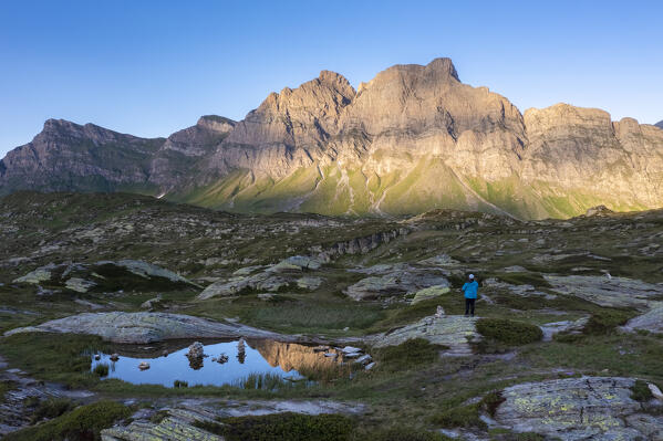 Aerial view of a pond reflecting Piz Uccello at sunset in San Bernardino pass. Graubünden, Moesa district, Switzerland, Europe.