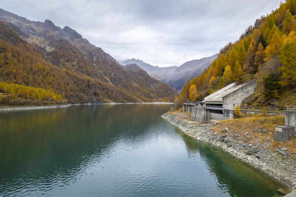 View of Lago dei Cavalli and its dam with Pizzo d'Andolla in autumn. Alpe Cheggio, Antrona Valley, Piedmont, Verbano Cusio Ossola, Italy.