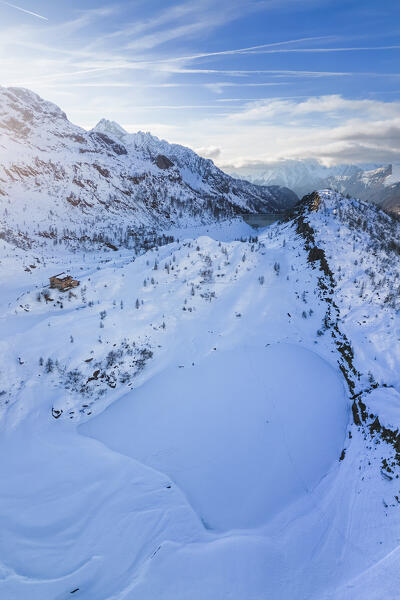 View of the Rifugio Calvi and Rotondo lake at sunset in winter. Carona, Val Brembana, Alpi Orobie, Bergamo, Bergamo Province, Lombardy, Italy, Europe.