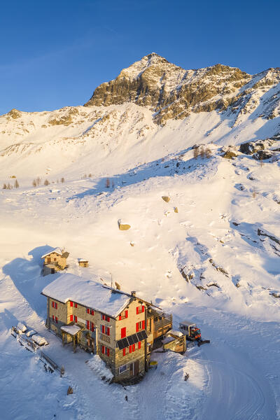 Sunset in front of Rifugio Cristina and Pizzo Scalino in winter. Lanzada, Valmalenco, Valtellina, Sondrio district, Lombardy, Italy, Europe.