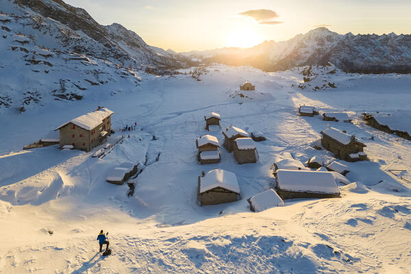 Sunset at Alpe Prabello and Rifugio Cristina in winter with Mount Disgrazia in the background. Lanzada, Valmalenco, Valtellina, Sondrio district, Lombardy, Italy, Europe.