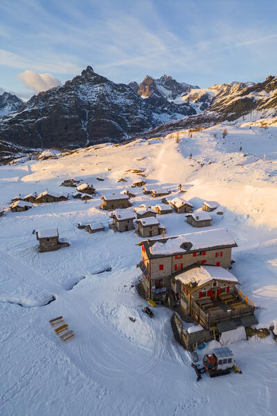 Sunset in front of Sasso Moro and Rifugio Cristina in winter. Alpe Prabello, Lanzada, Valmalenco, Valtellina, Sondrio district, Lombardy, Italy, Europe.