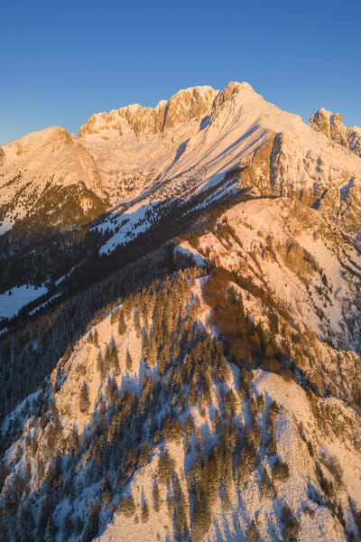 Aerial view of Monte Gulter and the Presolana massif after a winter snowfall at sunrise. Presolana pass, Castione della Presolana, Seriana Valley, Bergamo province, Lombardy, Italy.