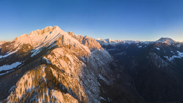 Aerial view of Monte Gulter and the Presolana massif after a winter snowfall at sunrise. Presolana pass, Castione della Presolana, Seriana Valley, Bergamo province, Lombardy, Italy.