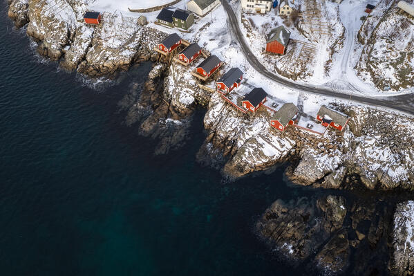 View of the Hamnøya island with the famous red rorbuer and the Lilandstinden mountain in Reine Bay during winter. Lofoten Islands, Norway.