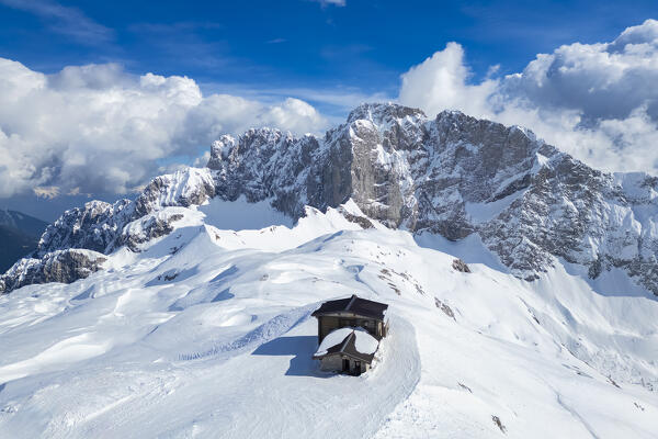 Aerial view of the snow-covered north face of the Presolana mountain and the Rifugio Aquila in winter. Val di Scalve, Bergamo district, Lombardy, Italy, Southern Europe.