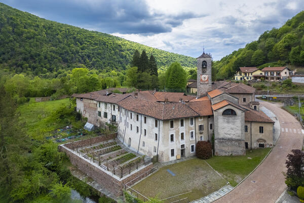 Aerial view of the ancient Badia di San Gemolo in Ganna on a spring day. Valganna, Varese district, Lombardy, Italy.