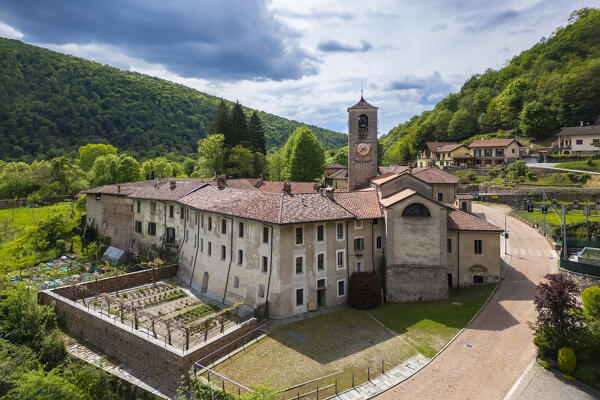 Aerial view of the ancient Badia di San Gemolo in Ganna on a spring day. Valganna, Varese district, Lombardy, Italy.