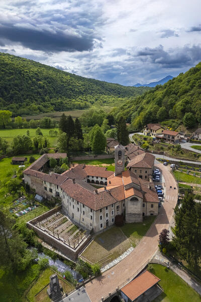 Aerial view of the ancient Badia di San Gemolo in Ganna on a spring day. Valganna, Varese district, Lombardy, Italy.