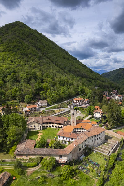 Aerial view of the ancient Badia di San Gemolo in Ganna on a spring day. Valganna, Varese district, Lombardy, Italy.