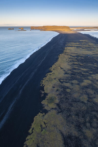 Aerial view of Reynisfjara beach at sunrise towards Dyrhólaey cliffs. Vík í Mýrdal, Southern Iceland, Iceland, Northern Europe.