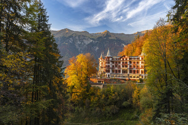 View of the Giessbach waterfalls and Grand Hotel in autumn at sunset. Iseltwald, Lake Brienz, Bernese Oberland, Interlaken-Oberhasli district, Canton of Bern, Switzerland.