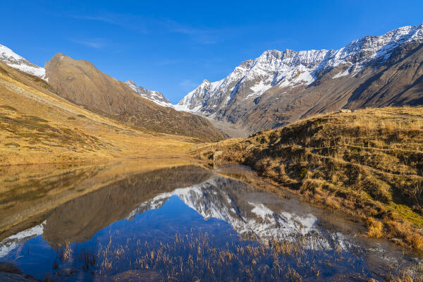 View of the Guggisee in Lotschental valley in autumn. Bernese Alps, canton of Valais, Switzerland.
