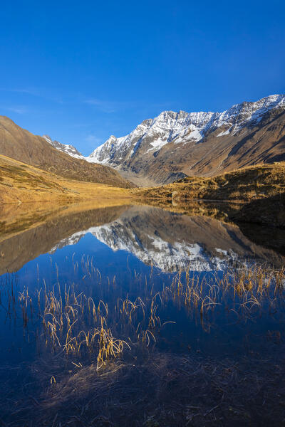 View of the Guggisee in Lotschental valley in autumn. Bernese Alps, canton of Valais, Switzerland.
