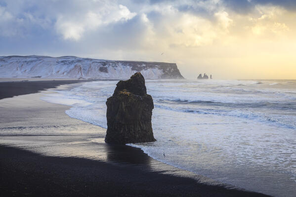 View of at sunset in winter at Reynisfjara beach with Arnardrangur stack. Vík í Mýrdal, Southern Iceland, Iceland, Northern Europe.