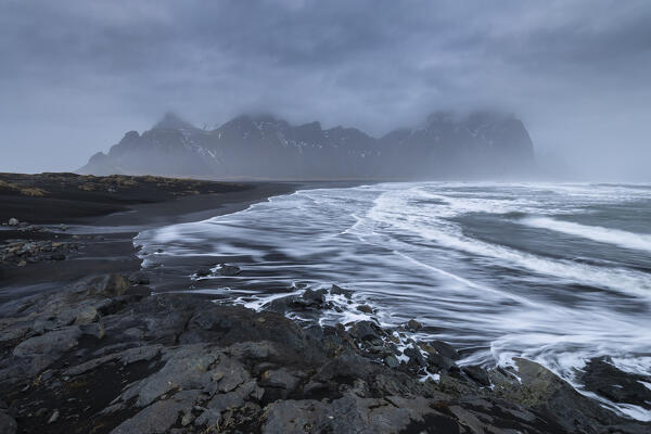 View of the sea waves on the beach in front of Vestrahorn mountain. Stokksnes peninsula, Hofn, Austurland, Iceland, Europe.