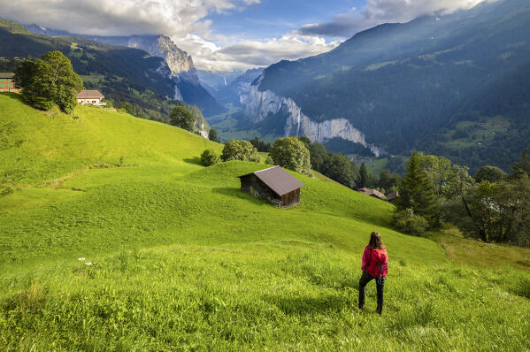 View of a tourist admiring Lauterbrunnen valley from Wengen town in summer. Wengen, Canton of Bern, Switzerland, Europe