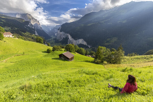 View of a tourist admiring Lauterbrunnen valley from Wengen town in summer. Wengen, Canton of Bern, Switzerland, Europe