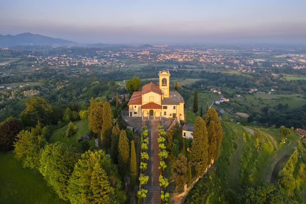 View of Santuario della Beata Vergine del Carmelo at the top of a hill at sunset in spring. Montevecchia, Lecco district, Lombardy, Italy.